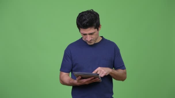 Homme hispanique penser tout en utilisant une tablette numérique — Video