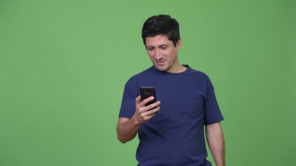 Hombre hispano usando el teléfono y recibiendo buenas noticias — Vídeos de Stock