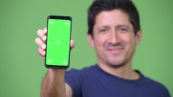 Счастливый латиноамериканец показывает телефон — стоковое видео