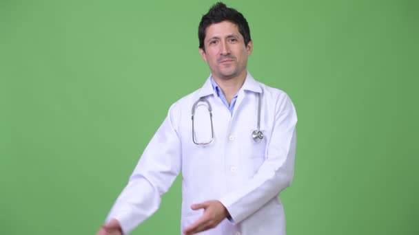 Happy Hispanic man doctor showing something — Stock Video