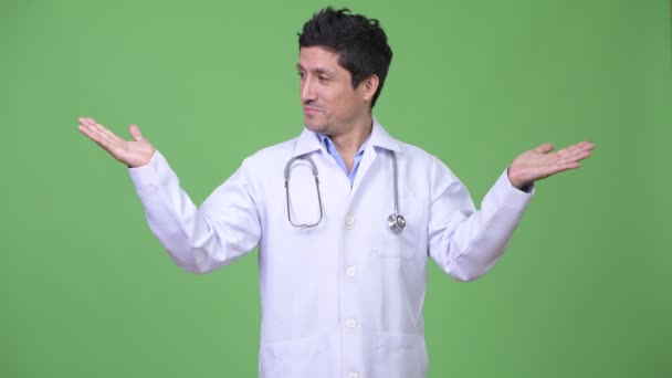 Латиноамериканського чоловік лікар порівняння щось — стокове відео