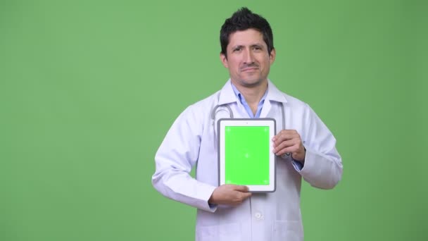 Feliz hispano hombre médico mostrando tableta digital — Vídeo de stock