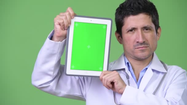 Feliz hispano hombre médico mostrando tableta digital — Vídeos de Stock