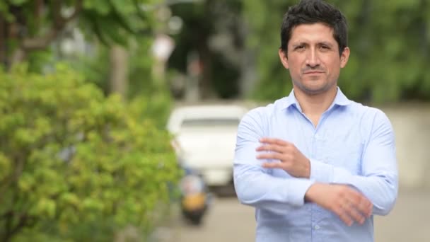 Homme d'affaires hispanique avec les bras croisés à l'extérieur — Video