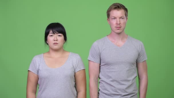 Junges multiethnisches Paar blickt gemeinsam in entgegengesetzte Richtungen — Stockvideo