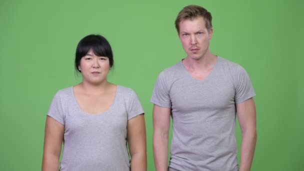 Jeune couple multi-ethnique parlant avec colère à la caméra — Video