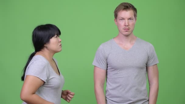 Arga överviktiga asiatisk kvinna talar för att lugna ung man — Stockvideo