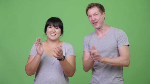 Joven feliz pareja multiétnica aplaudiendo juntas — Vídeo de stock