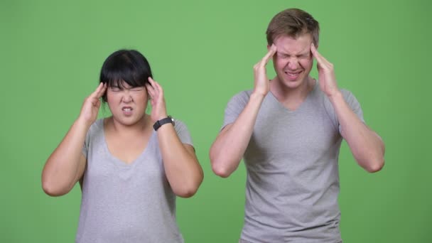 Молодая многонациональная пара испытывает головную боль вместе — стоковое видео