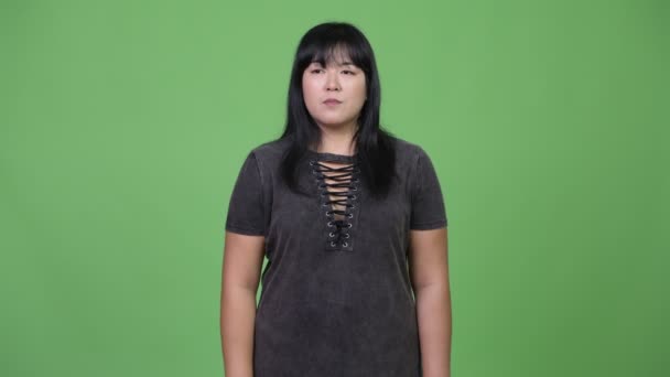 Счастливая толстая азиатка, указывающая пальцем — стоковое видео