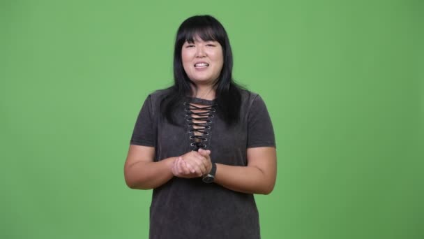 Schöne übergewichtige asiatische Frau präsentiert etwas — Stockvideo