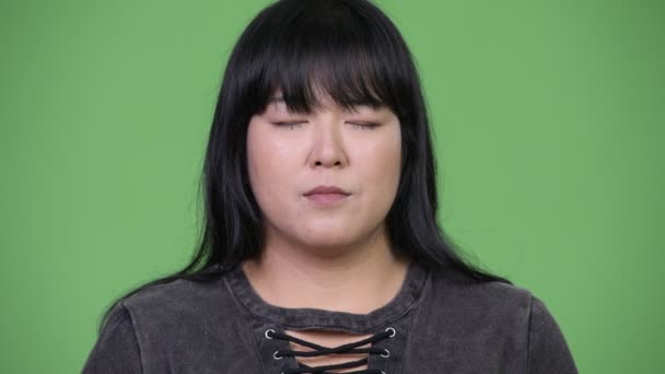 Feliz mujer asiática con sobrepeso relajándose con los ojos cerrados — Vídeos de Stock