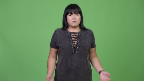 Beautiful overweight Asian woman shrugging shoulders — Stock Video