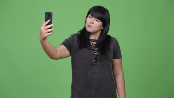 Beautiful overweight Asian woman taking selfie — Stock Video