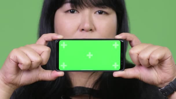 Heureuse femme asiatique en surpoids montrant téléphone — Video