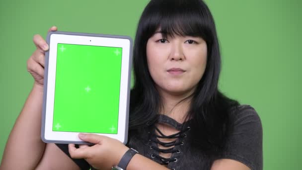 Felice sovrappeso donna asiatica mostrando tablet digitale — Video Stock
