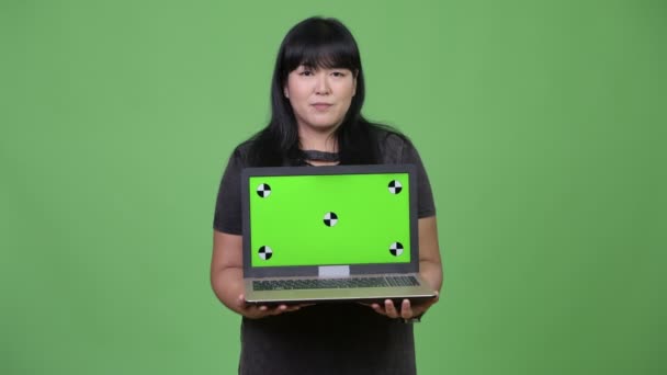 Happy overweight Asian woman showing laptop — Stock Video