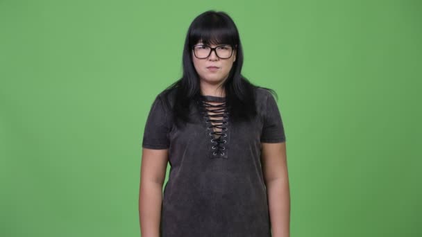 Belle femme asiatique en surpoids portant des lunettes avec les bras croisés — Video