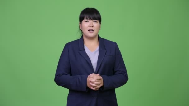 Красивая толстая азиатская бизнесвумен представляет что-то — стоковое видео