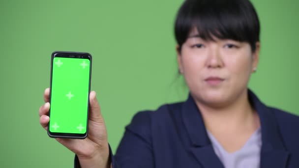 Glücklich übergewichtig asiatische Geschäftsfrau zeigt Telefon — Stockvideo