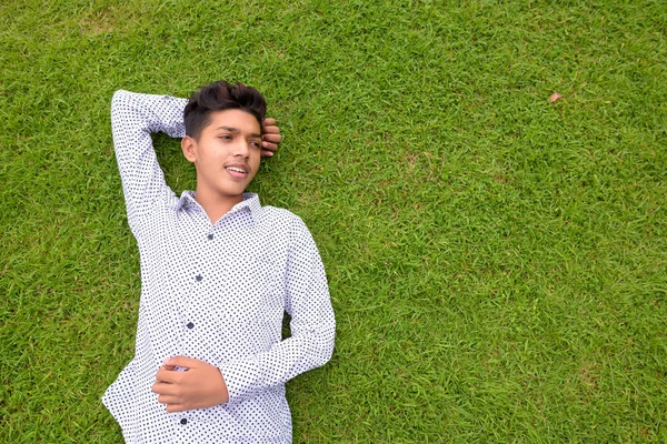 Portré, fiatal indiai tizenéves fiú pihentető a parkban — Stock Fotó