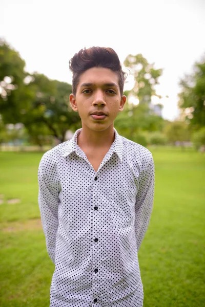 Retrato de jovem adolescente indiano relaxante no parque — Fotografia de Stock