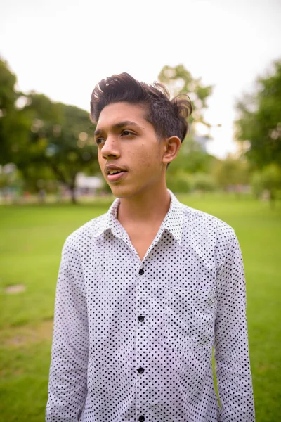 Retrato de jovem adolescente indiano relaxante no parque — Fotografia de Stock