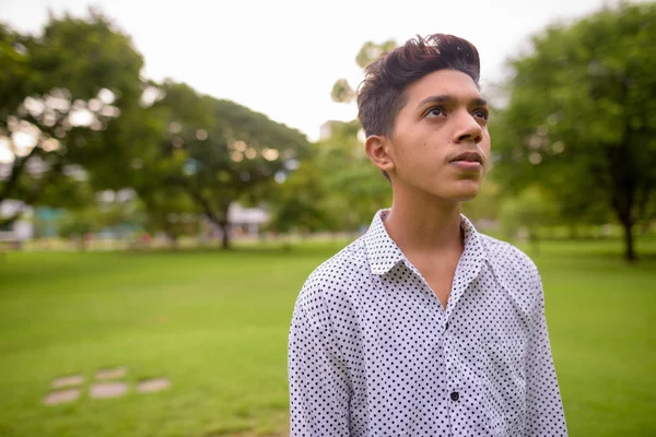 Portrait of young Indian teenage boy relaxing at the park — Stock Photo, Image