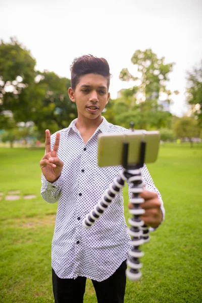 Retrato de jovem adolescente indiano relaxante no parque — Fotografia de Stock