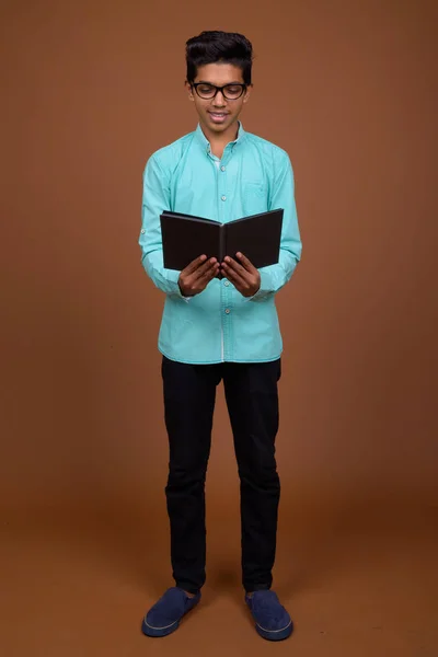 Young Indian boy wearing blue shirt looking smart against brown — Stock Photo, Image