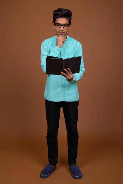 Young Indian boy wearing blue shirt looking smart against brown — Stock Photo, Image