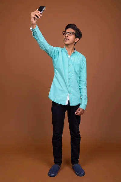 Young Indian boy wearing blue shirt looking smart against brown — Stock Photo, Image