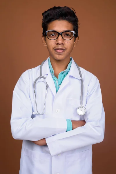 Joven médico niño indio con anteojos contra el backgro marrón —  Fotos de Stock