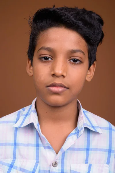 Ινδική αγόρι που φοράει καρό πουκάμισο εναντίον καφέ backgroun — Φωτογραφία Αρχείου