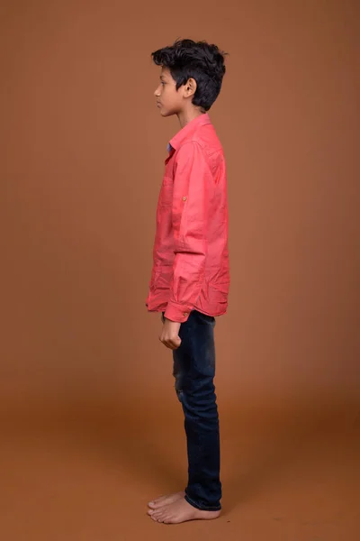 Indischer Junge trägt schicke Freizeitkleidung gegen braunen Bac — Stockfoto