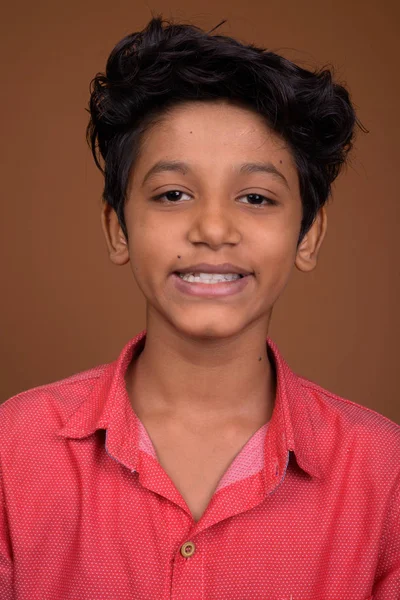 Joven niño indio usando ropa casual inteligente contra bac marrón — Foto de Stock