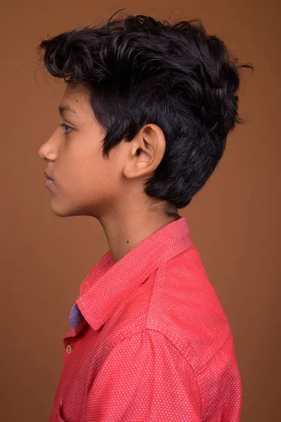 Indický chlapec nosí ležérní oblečení proti hnědé bac — Stock fotografie
