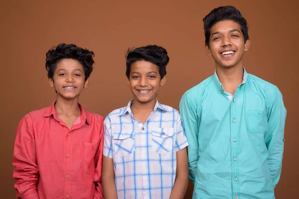 Три молодий індійський брати разом коричневий тлі — стокове фото