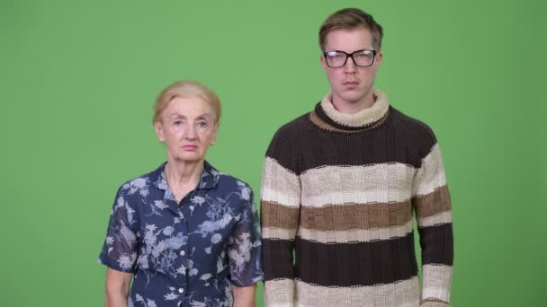 Grandmother and grandson together against green background — Stock Video