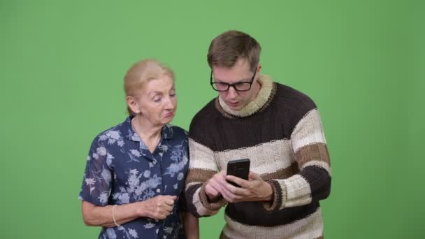 Glad mormor och barnbarn använder telefonen sedan ger tummen upp tillsammans — Stockvideo