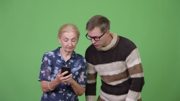 Happy grandmother and grandson using phone then giving thumbs up together — Stock Video