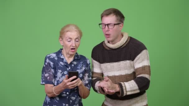 Abuela y nieto usando el teléfono y luego recibiendo malas noticias juntos — Vídeos de Stock