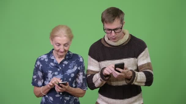 Щаслива бабуся і онук використовують телефон і спілкуються разом — стокове відео