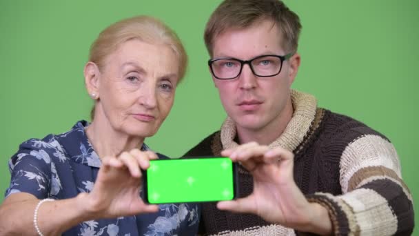 Glad mormor och barnbarn visar telefon tillsammans — Stockvideo
