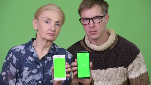 Gelukkig oma en kleinzoon telefoons samen tonen — Stockvideo