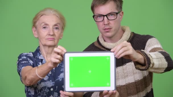 Happy grandmother and grandson showing digital tablet together — Stock Video