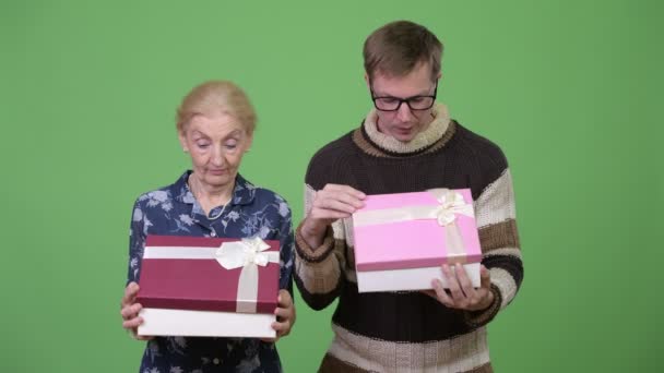 Счастливая бабушка и внук открывают подарочную коробку вместе — стоковое видео