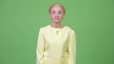 Gülümseyen ve düşünme mutlu üst düzey iş kadını stüdyo çekim