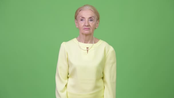 Studioaufnahme einer glücklichen Seniorin, die lächelt und denkt — Stockvideo