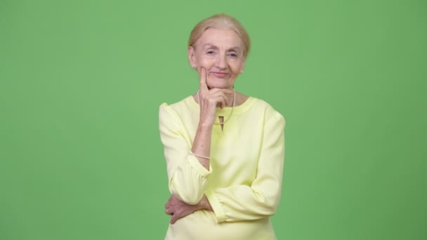 Glücklich schöne ältere Geschäftsfrau denken, während sie nach oben schaut — Stockvideo